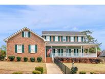 Charming brick home with a spacious front porch and manicured lawn at 135 Oakpark Ter, Mcdonough, GA 30253