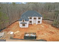 View of new construction home with black roof and unfinished landscaping at 2015 Fontainbleau Dr, Conyers, GA 30094