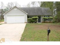 Charming single-story home featuring a two-car garage and a well-maintained front lawn at 999 Dixie Dr, Jonesboro, GA 30236