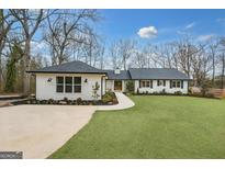 Charming single-story home featuring a well-manicured lawn, black roof, and a welcoming walkway at 757 Fischer Rd, Sharpsburg, GA 30277