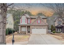 Charming two-story home featuring brick and siding with red shutters and a two-car garage at 750 Summerstone Ln, Lawrenceville, GA 30044