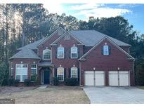 Charming two-story brick home with a three-car garage and mature landscaping in a quiet neighborhood at 100 Windmeadow Way, Fayetteville, GA 30214