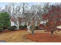 Charming home featuring a stone facade, manicured landscaping, and inviting curb appeal at 9135 Woodhaven Way, Mcdonough, GA 30253