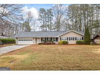 Charming ranch-style home featuring a well-manicured front yard, attached garage, and inviting entryway at 334 Nancy Sw Ct, Lilburn, GA 30047