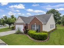Charming single-Gathering home featuring a well-manicured lawn and a combination of brick and vinyl siding at 410 Mockingbird Dr, Loganville, GA 30052