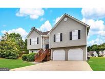 Charming two-story home with a well-maintained lawn, attached two-car garage, and inviting front entrance at 1202 Grove Trail Pass, Douglasville, GA 30134