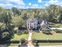 Magnificent brick home with manicured lawn, mature trees, and a grand entrance with stately white columns at 125 Turnberry Cir, Fayetteville, GA 30215