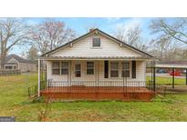 Charming single-story home featuring a brick porch and black railing, offering a welcoming curb appeal at 110 Bevis Cir, Bowdon, GA 30108