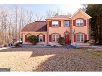 Inviting two-story home featuring red shutters, beautiful landscaping, and a well-manicured lawn at 110 Cardinal Ridge Ct, Fayetteville, GA 30214