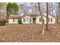 Charming one-story home with green door, red shutters, and well-maintained landscaping, nestled in a quiet neighborhood at 390 Marsha Way, Sharpsburg, GA 30277