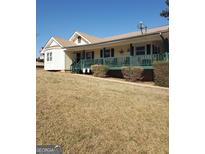 Charming ranch-style home with a spacious porch and well-maintained lawn, offering a welcoming curb appeal at 9000 Edinburg Dr, Winston, GA 30187