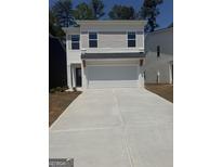 Two-story home featuring a two-car garage, a dark front door, and a long concrete driveway at 4856 Station Ln # 21, Union City, GA 30349