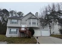 Charming two-story home with a well-maintained lawn and two-car garage at 1913 Boulder Ridge Pkwy, Ellenwood, GA 30294