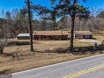 Charming single-story home with brown siding, surrounded by mature trees and a well-maintained front yard at 8380 Cedar Grove & 8400 Teal Road Rd, Fairburn, GA 30213