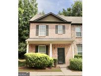 Charming two-story brick townhome with a covered front porch and well-maintained landscaping at 1406 Bayrose Cir # 6B, East Point, GA 30344