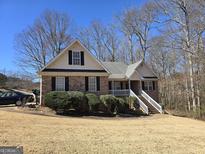 Charming brick home with mature landscaping and welcoming front porch and covered entrance at 270 Huntington St, Covington, GA 30016
