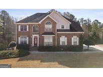 Two-story brick home featuring white shutters, a red front door, and manicured landscaping at 123 Stratmore Pl, Stockbridge, GA 30281