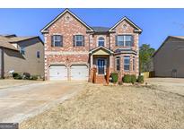 Beautiful two-story brick home with attached two car garage and manicured front yard at 536 Caledon Way, Hampton, GA 30228