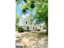 Charming two-story home with light gray siding and white shutters surrounded by mature trees at 1209 Willow Creek Nw Ct, Conyers, GA 30012