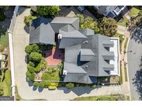 Stunning aerial view of a home with lush landscaping, a brick patio, and a dark roof, showcasing its architectural design at 3786 Turnberry Ct, Duluth, GA 30096