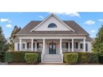 Charming two-story home featuring a welcoming front porch with white columns and a beautifully landscaped yard at 120 Highland Park Dr, Sharpsburg, GA 30277