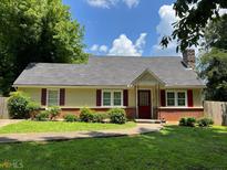 Charming home featuring a red door, chimney, and lush landscaping at 2681 Oldknow Dr, Atlanta, GA 30318