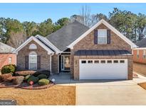 Charming brick home featuring manicured landscaping, a two-car garage and inviting front entrance at 509 Carleton Pl, Locust Grove, GA 30248