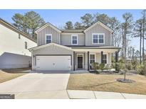 Two-story home featuring a two-car garage, covered porch, and manicured lawn at 133 Vivian Ln, Peachtree City, GA 30269