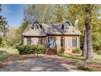 Charming brick home with dormer windows, blue shutters, and landscaped front yard at 2229 Rugby Avenue, Atlanta, GA 30337