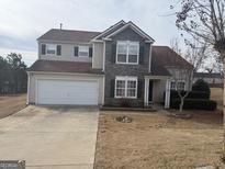 Two-story home featuring stone accents and a two-car garage on a well-manicured lawn at 1631 Royal Ives Dr, Lawrenceville, GA 30045