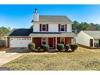 Charming two-story home with a well-maintained front yard, brick accents, and a two-car garage at 261 Whistle Way, Locust Grove, GA 30248