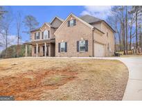 Inviting two-story brick home featuring dark shutters and a spacious front yard with an attached two-car garage at 224 Jester Ct, Mcdonough, GA 30252