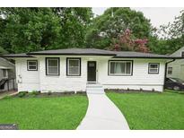 Charming home featuring a manicured lawn, a fresh paint job, and a welcoming walkway at 2508 Sylvan Rd, East Point, GA 30344