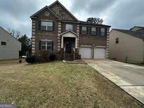 Charming two-story home with a brick facade, well-maintained lawn, and a two-car garage at 365 Lamont Ln # 279, Hampton, GA 30228