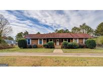 Charming single-story home featuring a well-maintained lawn and inviting front entrance at 5687 Highway 212 N, Covington, GA 30016