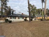 Charming single story home with a white painted brick exterior and lovely dark shutters at 2577 Headland Dr, East Point, GA 30344