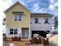 New construction home featuring beige siding, a two-car garage, and visible building materials in the front yard at 106 Silverton Dr, Dacula, GA 30019