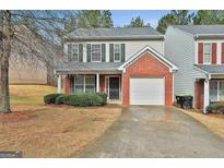 Charming two-story home with a brick accent, attached garage, and well-maintained front yard at 4607 Ravenwood Loop, Union City, GA 30291