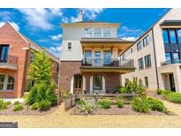 Charming brick and siding home with a quaint front yard and cozy patio seating area at 135 Kelmscott Ln, Fayetteville, GA 30214