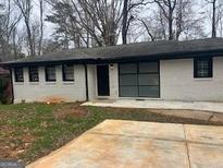 Charming single-story home with a brick facade, dark window trim, concrete driveway, and cozy curb appeal at 3490 Primrose Pl, Decatur, GA 30032