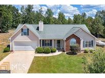 Charming one-story home features an attached garage, well-manicured lawn, and welcoming entryway at 25 Alcovy Forest Way, Covington, GA 30014