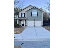 Two-story home with a two-car garage and a well-maintained front lawn at 7522 Springbox Dr, Fairburn, GA 30213