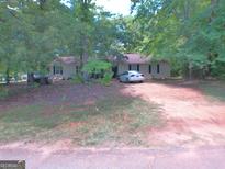 Charming one-story home featuring neutral siding, dark shutters, and a neatly maintained front yard with mature trees at 255 Countryside Ln, Covington, GA 30016