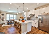 Bright kitchen features white cabinets, stainless steel appliances, and an island with seating at 429 Stagecoach Bnd, Smyrna, GA 30080