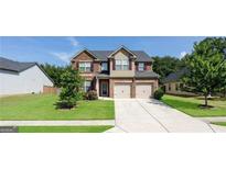 Charming two-story brick home featuring a well-manicured lawn and a two-car garage, perfect for Gathering living at 207 Birchwood Dr, Loganville, GA 30052