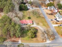 Sprawling property with a charming home featuring a bright red roof nestled among mature trees and lush landscaping at 1713 Bramlett Shoals Rd, Lawrenceville, GA 30045