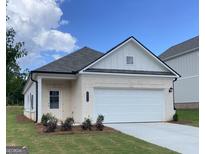 Charming single-story home featuring a brick facade, attached garage, and well-maintained landscaping at 10458 Trellis Lane (Lot 40), Hampton, GA 30228