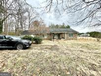 A single story home featuring a stone facade, covered porch, and a neatly landscaped front yard at 3210 Rogers Rd, Mcdonough, GA 30252