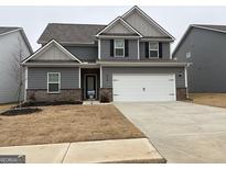 Charming two-story home featuring a two-car garage and landscaped front yard at 438 Prescott Way, Villa Rica, GA 30180