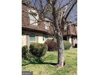 Charming townhome exterior with well-maintained landscaping and a mature tree in the front yard at 2978 Parc Lorraine # Building 4, Lithonia, GA 30038